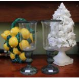 A decorative china lemon jug with a cream porcelain fruit decoration and a pair of storm lanterns