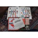 A stamp album together with an old fashioned condensed Monopoly game