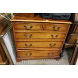 A modern yew wood chest of two over three drawers