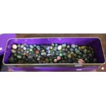 A tin box containing a large collection of assorted glass marbles