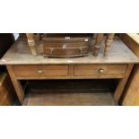 A pine kitchen work table, having plain top over two inline drawers, 76cm x 132cm