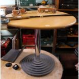 A circular pine effect table on steel base