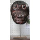 A painted Balinese monkey mask, on stand - Felix Dennis collection