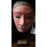 A painted Balinese mask, on stand - Felix Dennis collection