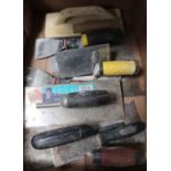 A box containing a selection of trowels/plasterers equipment