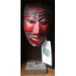 A painted Balinese devil mask, on stand - Felix Dennis Collection