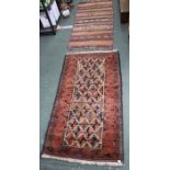 A hand knotted woollen carpet with applied pom-poms