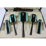 Deakin and Francis Ltd, an Art Deco dressing table set, silver having black and green enamel with a