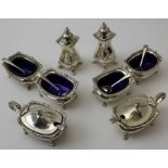 Two Georgian design silver plated condiment sets, each comprising two salts with blue glass liners,