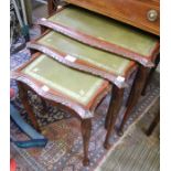 A nest of three green leather top tables