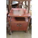 A dark wood two drawer cabinet on castors