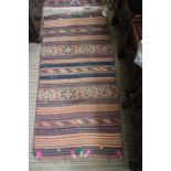 A hand knotted woollen carpet with applied pom-poms