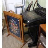 A late Victorian ebonised Davenport desk together with a firescreen inset a woolwork panel