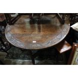 An 19th century oval dropleaf oak dining table with chip carve decoration
