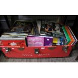 A red travelling trunk containing a large selection of LP's