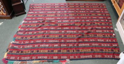 A striped flat weave geometric tent rug part fringed