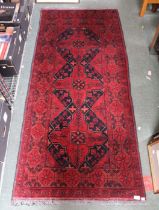A woven woollen floral design long rug 86 x 193 cm