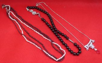 A collection of four various necklaces, includes garnets and pearls