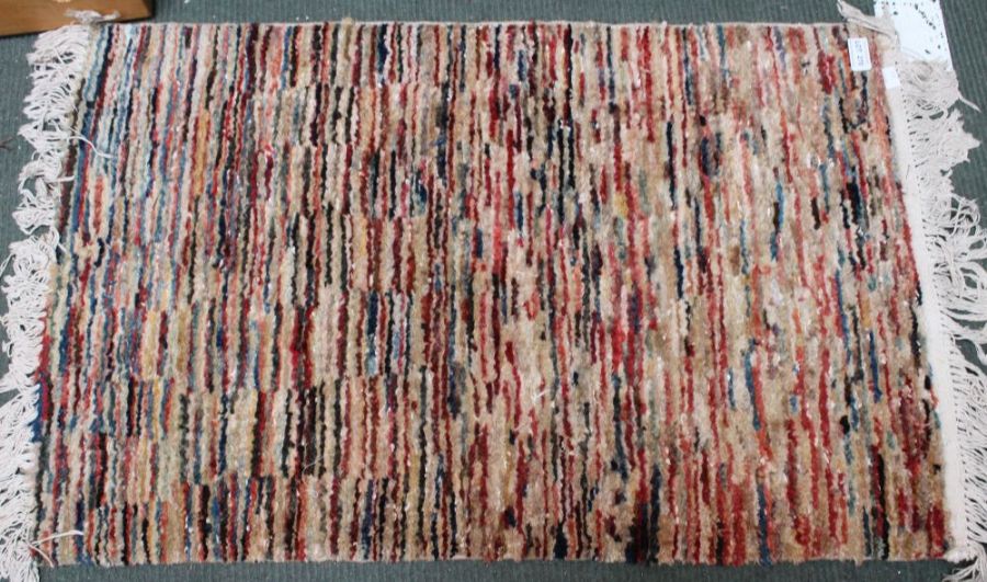 A modern patterned woollen floor mat with tassel fringe 86 x 56 cm