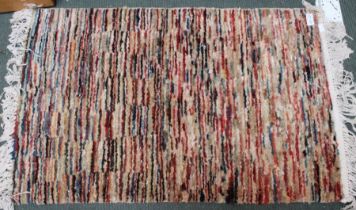 A modern patterned woollen floor mat with tassel fringe 86 x 56 cm