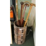 A circular wooden and brass bound vintage stick stand with contents