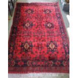 A woven woollen red ground carpet having stylised floral decoration 125 x 195 cm