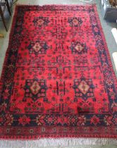 A woven woollen red ground carpet having stylised floral decoration 125 x 195 cm