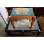A glass top coffee table with tapestry decoration with a tapestry top pine stool