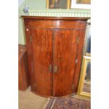 A Georgian mahogany wall hanging corner cupboard with inlay motif and butterfly hinges