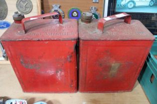 Two red vintage fuel cans with brass tops