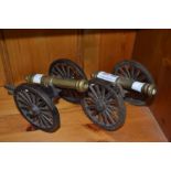 A pair of miniature cast and brass desk top cannons