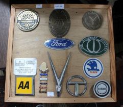 A presentation board mounted with metal car manufacturer badges, includes a Bugatti Owners Club