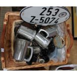 A wicker basket containing a selection of motoring tankards and trophies