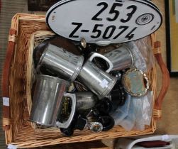 A wicker basket containing a selection of motoring tankards and trophies