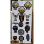 A presentation board of mounted metal motor club badges includes Ferranti, Simca, AA plus