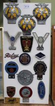 A presentation board of mounted metal motor club badges includes Ferranti, Simca, AA plus