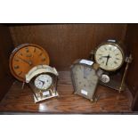 A brass mantle clock with three other similar vintage examples