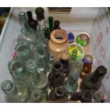 A box containing a selection of vintage bottles and four paper-weights