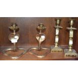 A pair of brass candlesticks in the form of cobras