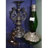 An ornate metal candle stick, arts and crafts style green glass bottle and a bronze figure