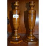 A pair of turned wooden candle sticks