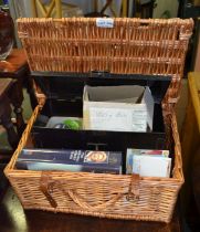 A wicker picnic basket containing car lights postcards etc