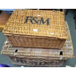 A large vintage wicker laundry basket with lid with a picnic basket branded F&M