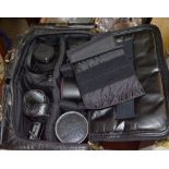 A black leather effect bag containing photographic equipment various