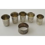 Five Russian silver vodka beakers, together with an engraved Russian silver napkin ring, having some