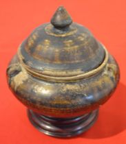 A South-East Asian pottery lidded bowl 12 cm high on a turned wood stand, mottled brown glaze