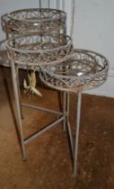 A wrought metal folding plant stand