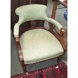 A 19th century carved wooden framed horseshoe backed low chair, with green damask upholstered back &