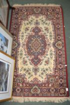 An Eastern design cream ground rug, fringed and bordered, 160cm x 94cm