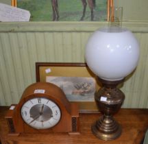 An oil lamp a clock and a maritime hand coloured print